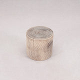 Round woven stool with geometric pattern on a light gray background