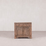 Vintage wooden cabinet with two doors and two drawers on a plain background