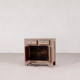 Wooden cabinet with two drawers and an open cabinet on a plain background