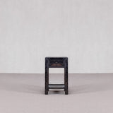 Wooden stool with a dark finish on a plain background