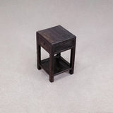 Small wooden side table with a drawer on a light gray background