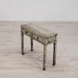 Vintage wooden side table with two drawers on a light wood floor.
