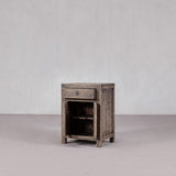 Wooden side table with a single drawer against a plain background