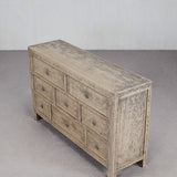 Wooden dresser with multiple drawers on a gray floor and background