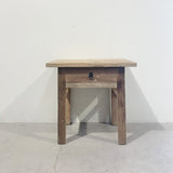 Wooden side table with a drawer on a plain background