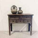 Wooden side table with carved details and two ceramic vases on a white background