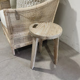 Wicker chair and stool on a concrete floor with a white wall background