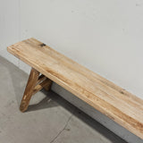 Wooden bench against a plain wall