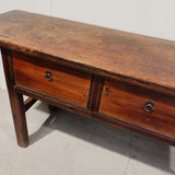 Wooden console table with two drawers on a plain background