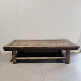 Vintage wooden coffee table against a plain white wall