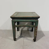 Vintage wooden table with green and black paint on a plain background