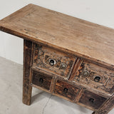 Wooden console table with intricate carvings on a white background