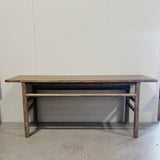 Wooden table against a plain white wall