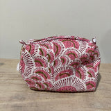 Pink and white patterned pouch on a wooden surface