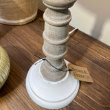 Decorative lamp with wooden base and white shade on a wooden surface, featuring a tag from Brown & Stone.
