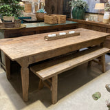 Wooden bench in a room with decorative items and plants