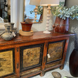 Wooden sideboard with decorative items including vases and a mirror.