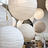 White paper lanterns hanging in a room with furniture and decor.