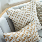 Patterned pillows on a light gray sofa in a home setting