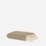 A folded woven throw blanket with cream fringe, shown on a clean white background.