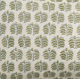 A close-up of a woven fabric with a repeating block-print pattern of stylized tree motifs in olive green and gray on a warm off-white background.