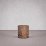 Wooden barrel on a gray floor with a plain white wall background