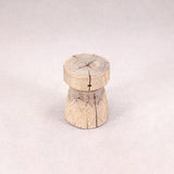 Wooden stool with a natural, textured surface on a light gray background
