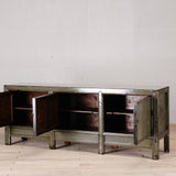 Vintage-style metal cabinet with open doors on a wooden floor against a white wall.