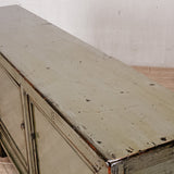 Vintage wooden sideboard with peeling paint on a white wall background