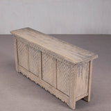 Wooden bench with intricate carvings on a plain background