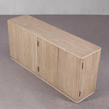 Wooden sideboard with slatted design on a gray floor and wall