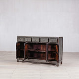 Vintage wooden sideboard with open doors on a light wooden floor against a white wall
