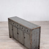 Vintage-style sideboard with a distressed finish on a wooden floor.