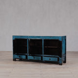 Vintage blue wooden cabinet on a wooden floor with a gray wall background