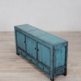 Vintage blue wooden cabinet on a wooden floor with a white wall background