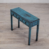 Blue wooden console table with three drawers on a wooden floor.