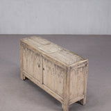 Wooden sideboard with a weathered finish on a gray floor and background