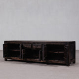 Vintage wooden TV stand with multiple drawers against a plain wall.
