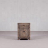 Wooden side table with a distressed finish on a plain background