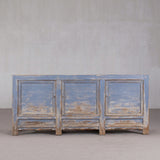 Vintage-style wooden cabinet with blue and brown distressed finish against a plain background