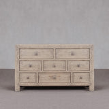 Wooden dresser with multiple drawers against a gray background