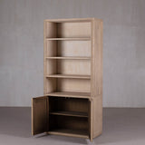 Wooden bookshelf with a door against a gray wall