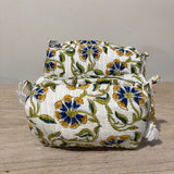 Floral-patterned fabric bag on a wooden surface with a neutral background