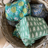 Basket with fabric rolls featuring green and blue patterns
