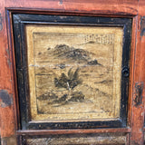 Close-up of a wooden panel with a printed design, possibly an eagle, on a cabinet.