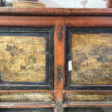 Vintage wooden cabinet with gold leaf panels and a tag on a blurred background