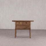 Wooden side table with two drawers against a plain background