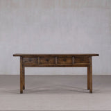 Wooden table with drawers against a plain wall