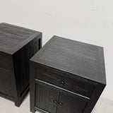 A pair of black wooden nightstands shown from an elevated angle against a plain off-white wall.
