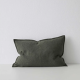 Dark gray pillow on a white surface with a light gray background